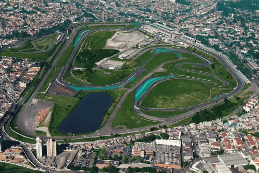 Vista aérea do Autódromo de Interlagos, com traçado completo cercado por áreas urbanas e vegetação