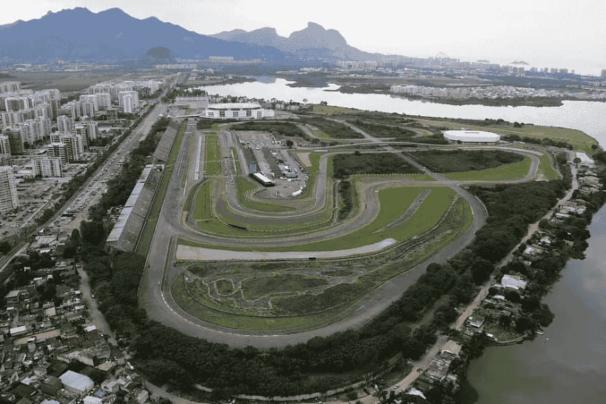 Vista aérea do antigo Autódromo de Jacarepaguá no Rio de Janeiro, com lagoas e montanhas ao fundo