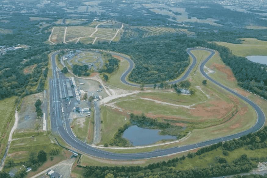 Vista aérea do Autódromo Internacional de Tarumã, com traçado sinuoso e vegetação ao redor