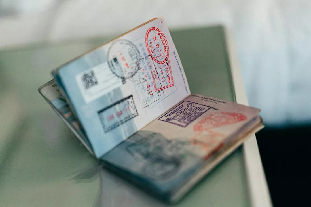 An open passport with multiple colorful ink stamps on the pages