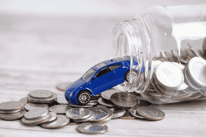 Carro em miniatura saindo de pote de vidro com moedas, simbolizando economia e custos com o veículo