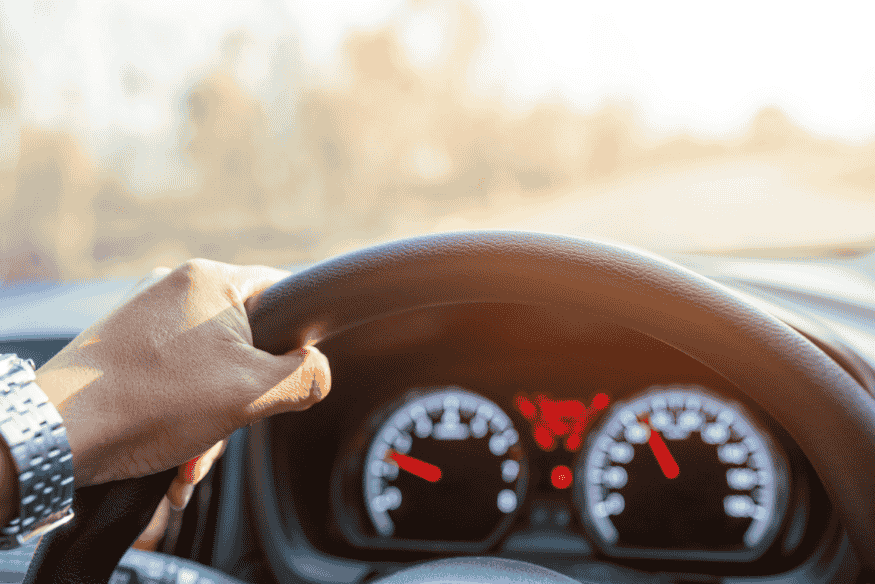 Motorista ao volante com painel de carro em destaque, representando a condução diária do veículo