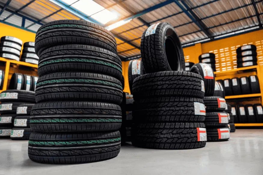 Estoque de pneus de diferentes modelos e tamanhos em loja automotiva.