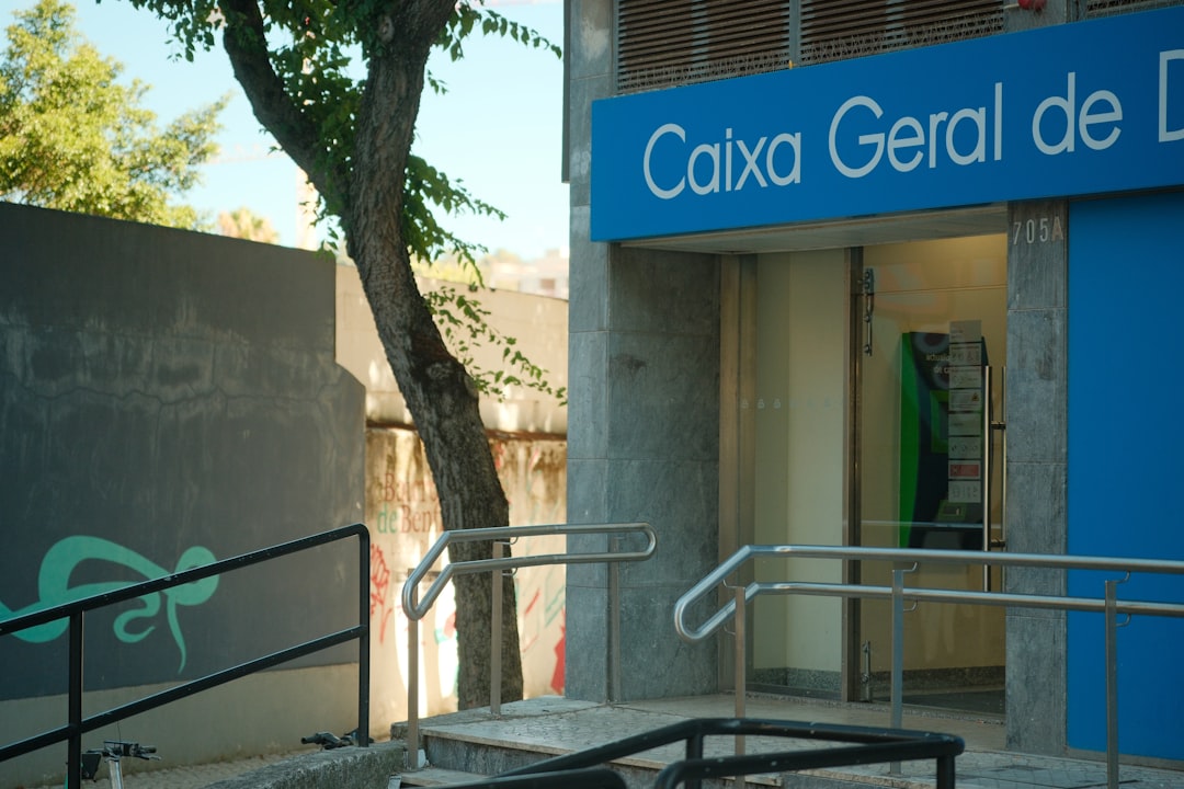 A Caixa Geral de Depósitos bank entrance with metal railings and a tree