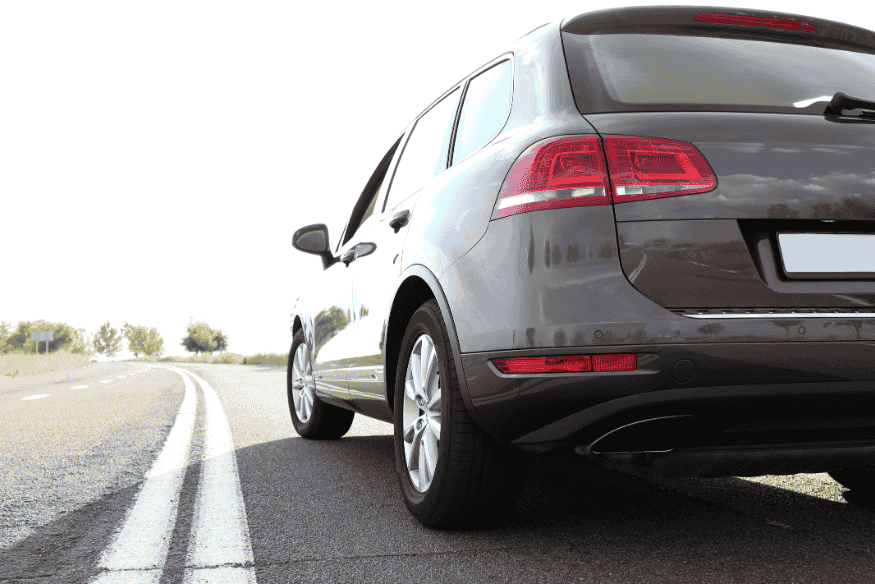 Carro de passeio com tração traseira em estrada aberta sob sol forte.