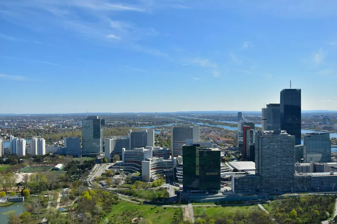 Modern cityscape with skyscrapers, green parks, and a winding river