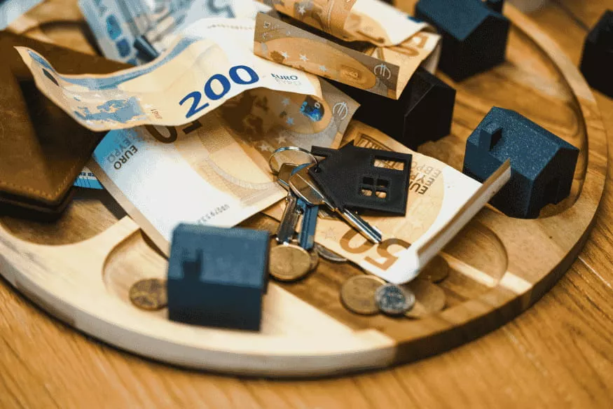Banconote in euro, chiavi e casette in miniatura, risparmio e pianificazione per matrimonio, casa e ristrutturazione senza andare in rosso.