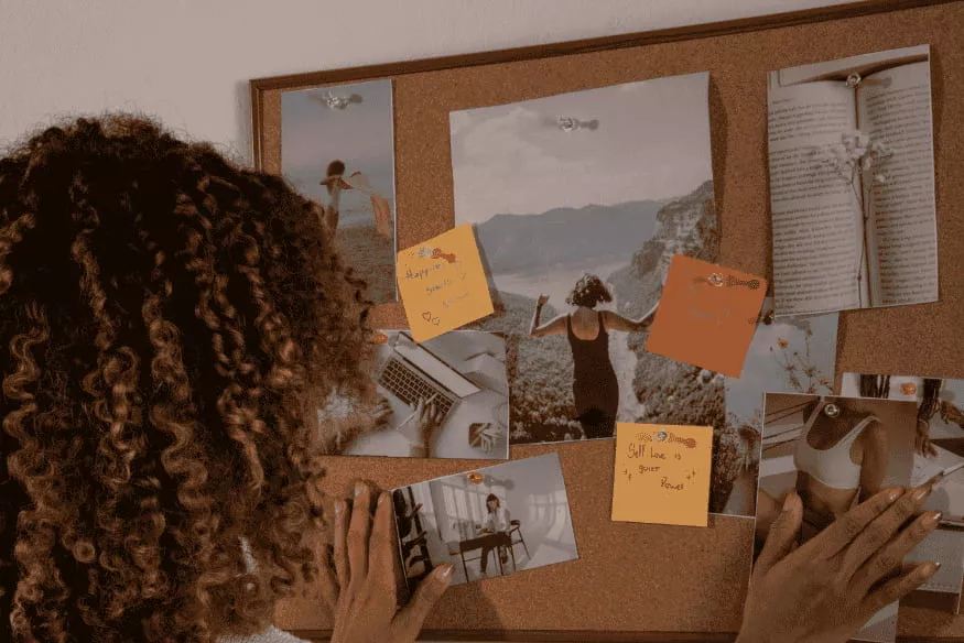 Vision board con foto e appunti, idea di obiettivi e risparmio da costruire con il primo stipendio.