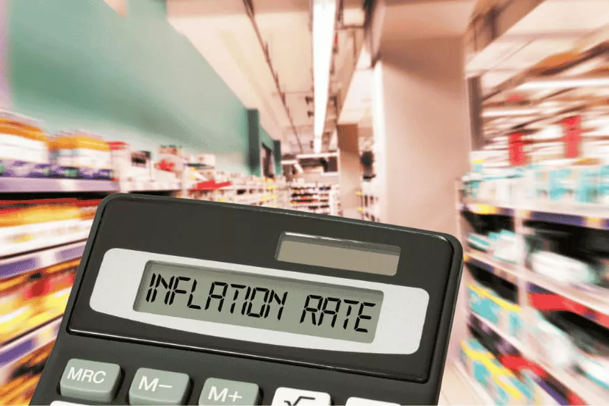Calcolatrice con “inflation rate” tra gli scaffali: inflazione e costo della spesa che incidono su rate e finanziamenti.