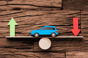 Carro azul em balança com setas verde e vermelha, representando valorização e desvalorização de veículos