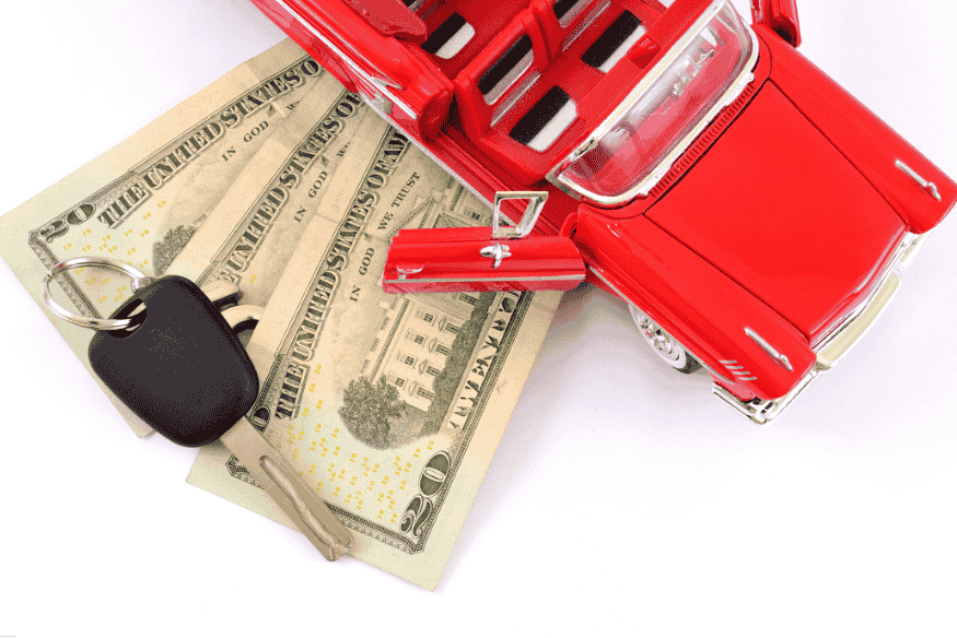 Miniatura de carro conversível com cédulas de dólar e chaves, simbolizando despesas com o veículo