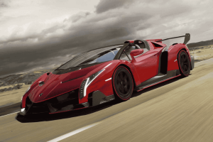 Lamborghini Veneno vermelha em alta velocidade em estrada deserta com céu nublado.