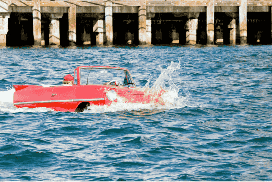 Amphicar vermelho navegando no mar, carro anfíbio conversível produzido para o público civil nos anos 60.